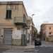 ...e a destra un caseggiato su cui  ben visibile una scritta risalente al Ventennio fascista. La palazzina fa angolo con via Carafa...